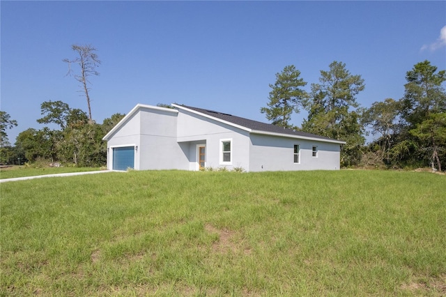 exterior space with a garage and a lawn