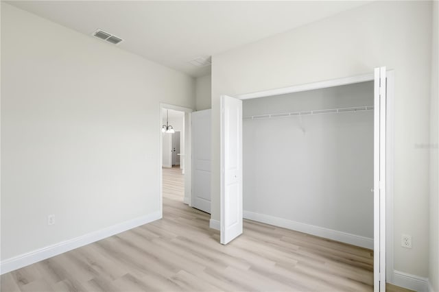 unfurnished bedroom with light hardwood / wood-style flooring and a closet