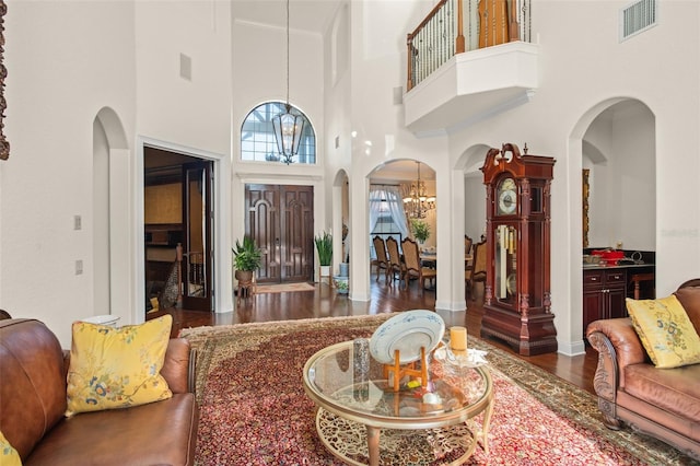 foyer featuring a towering ceiling, dark hardwood / wood-style flooring, and a chandelier