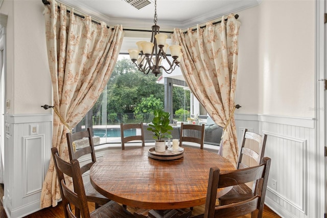 dining room featuring crown molding, dark wood-type flooring, and a chandelier