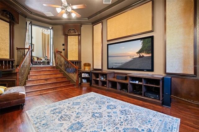 home theater featuring ornamental molding, dark wood-type flooring, and ceiling fan