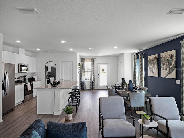 living area featuring visible vents, wood finished floors, and recessed lighting