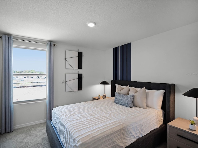 carpeted bedroom with a textured ceiling and baseboards