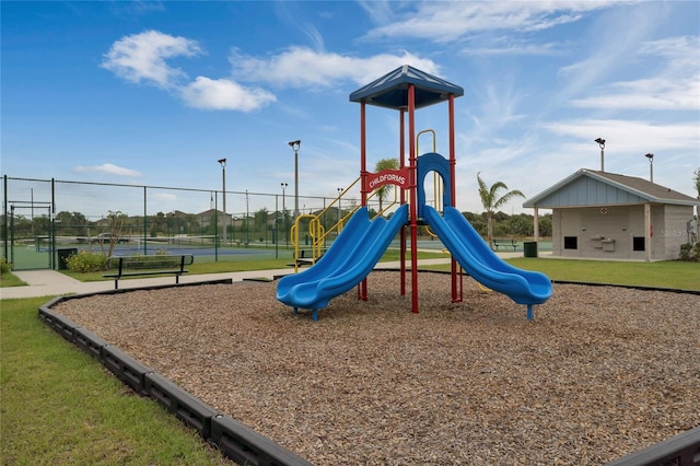 community playground with a tennis court and fence