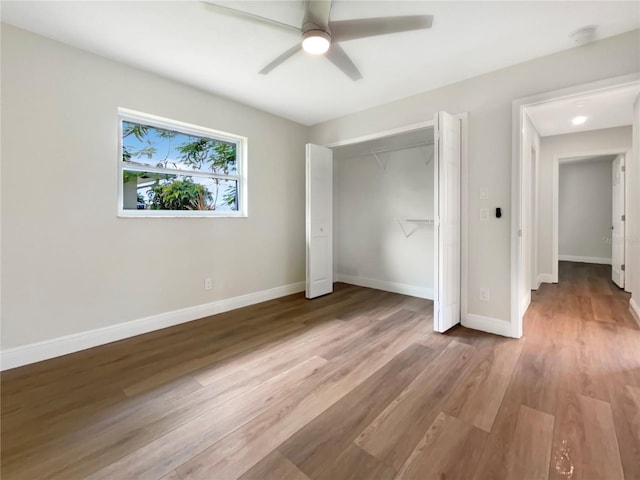 unfurnished bedroom featuring ceiling fan, hardwood / wood-style floors, and a closet