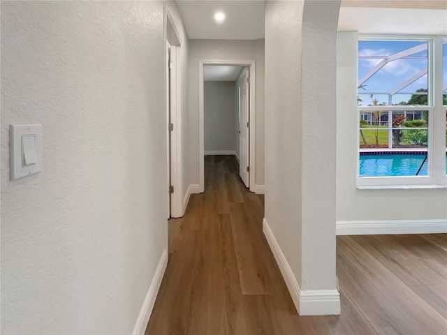 corridor with hardwood / wood-style flooring