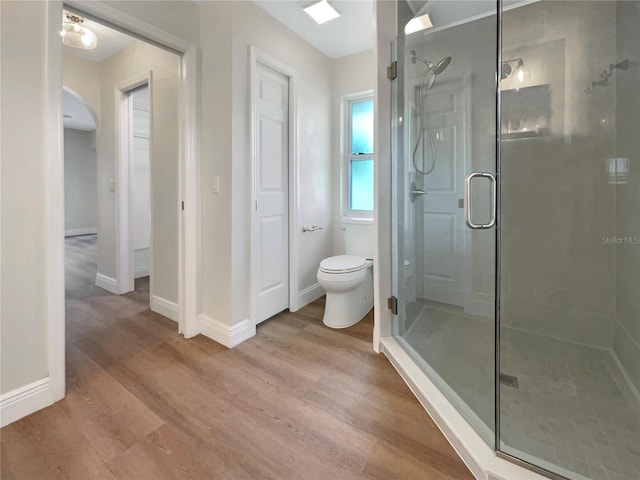 bathroom with walk in shower, wood-type flooring, and toilet