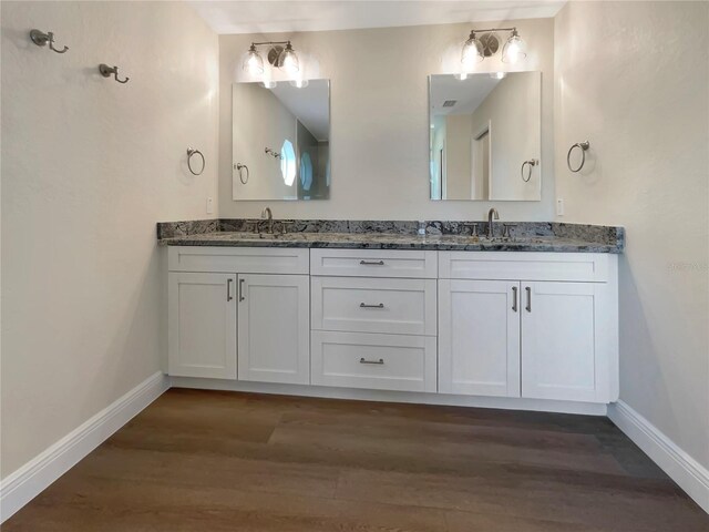 bathroom featuring hardwood / wood-style flooring and dual bowl vanity