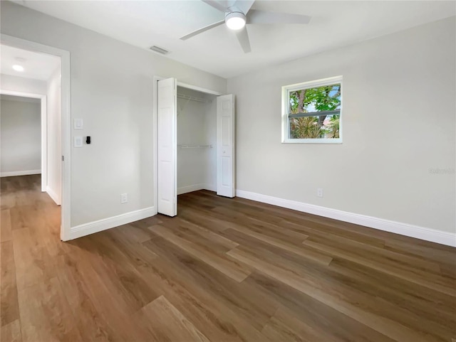 unfurnished bedroom featuring a closet, hardwood / wood-style floors, and ceiling fan