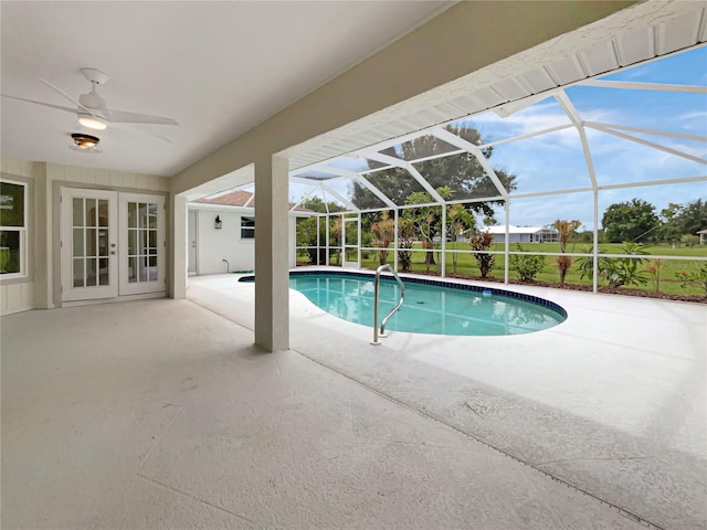 view of swimming pool with a patio, ceiling fan, glass enclosure, and french doors