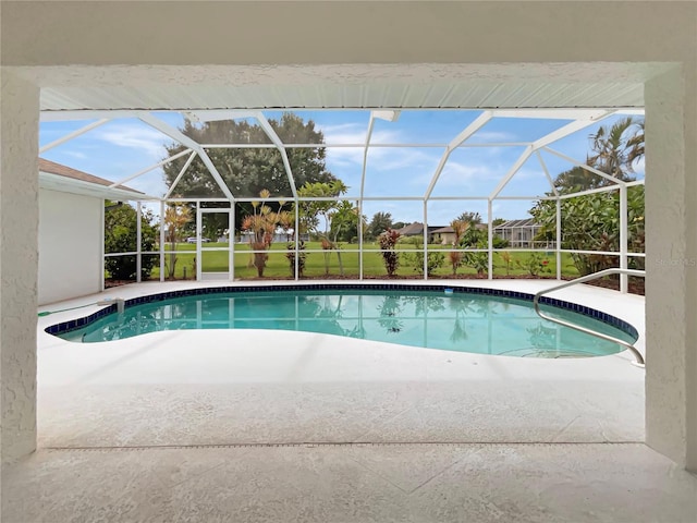 view of pool with a patio area and glass enclosure