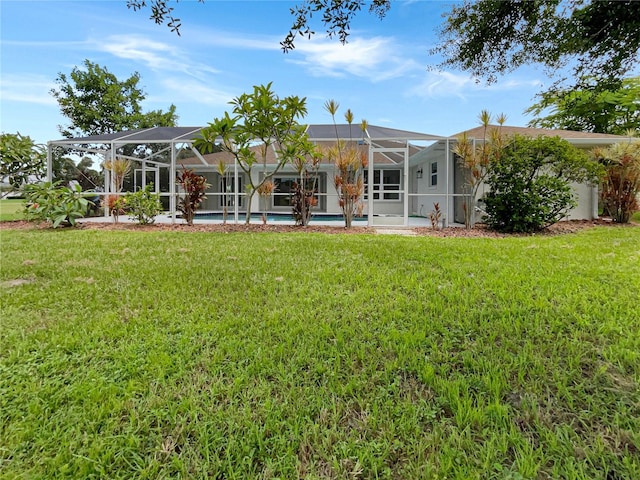 rear view of property with a lawn and a lanai