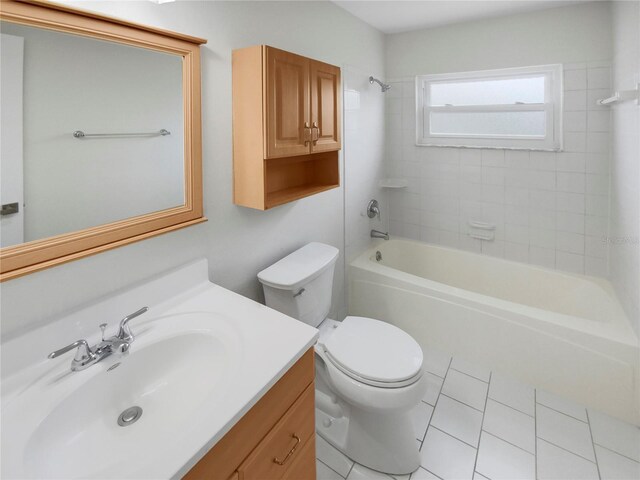 full bathroom with vanity, tiled shower / bath combo, toilet, and tile patterned flooring