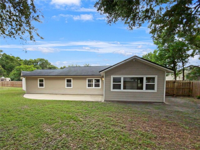 rear view of house with a patio area and a lawn