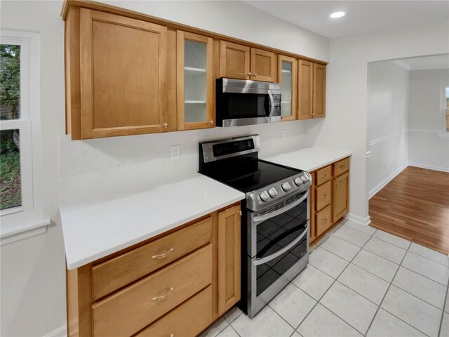 kitchen featuring decorative backsplash, appliances with stainless steel finishes, and light wood-type flooring