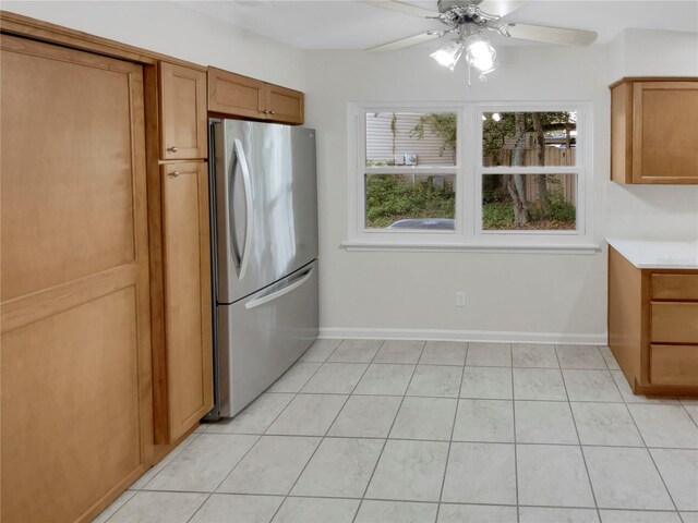 kitchen featuring stainless steel refrigerator, light tile patterned floors, and ceiling fan