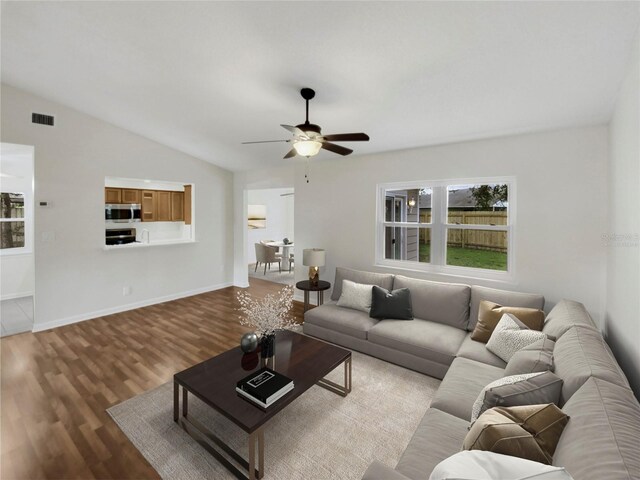 living room with hardwood / wood-style flooring, lofted ceiling, and ceiling fan