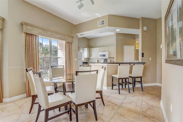 tiled dining space with ceiling fan