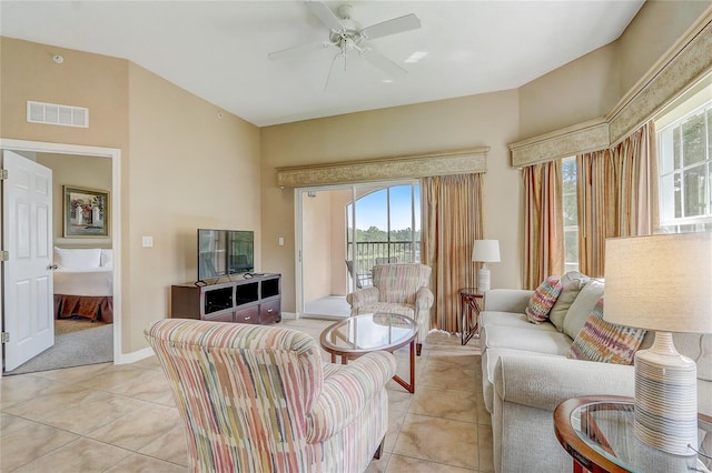 tiled living room featuring ceiling fan and plenty of natural light