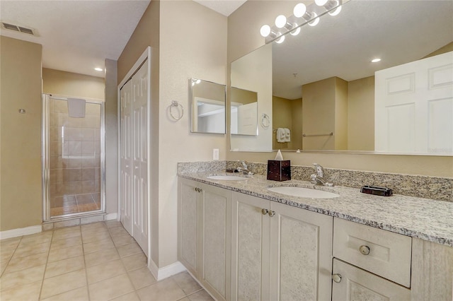 bathroom with double vanity, tile patterned floors, and a shower with shower door