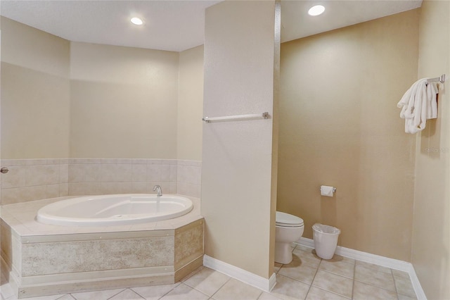 bathroom featuring tiled tub, toilet, and tile patterned flooring