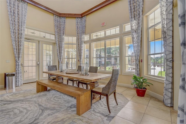 tiled dining room with crown molding and a towering ceiling