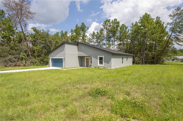 5277 SW 165th Street Rd, Ocala, FL 34473 - rear view of property featuring an attached garage, stucco siding, a lawn, and concrete driveway