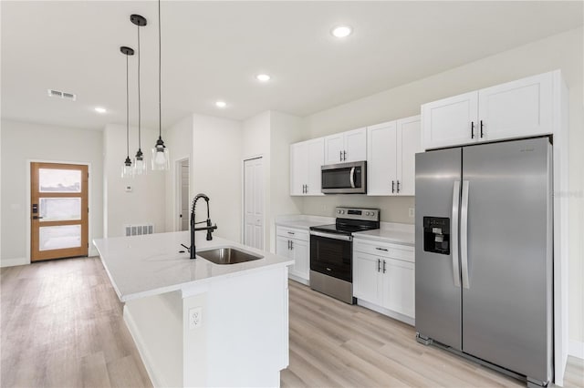 5277 SW 165th Street Rd, Ocala, FL 34473 - kitchen with appliances with stainless steel finishes, a sink, light wood-style flooring, white cabinets, and a kitchen island with sink