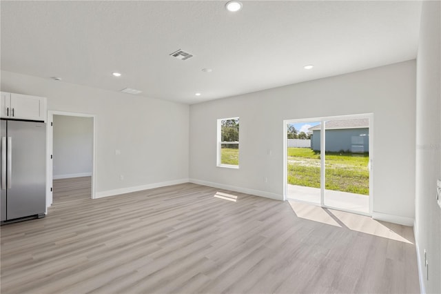 spare room with light hardwood / wood-style flooring