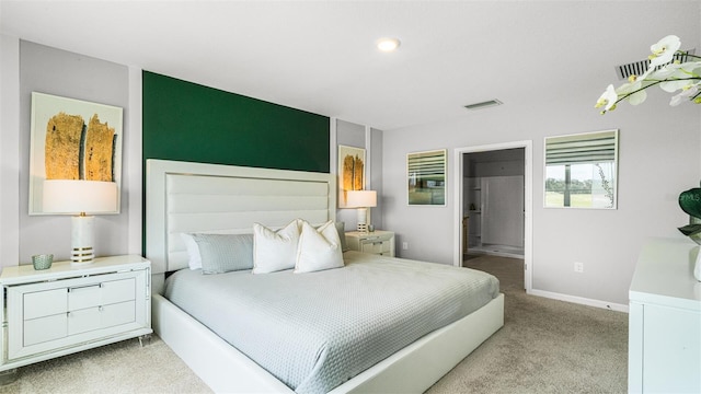 bedroom featuring ensuite bath and light colored carpet