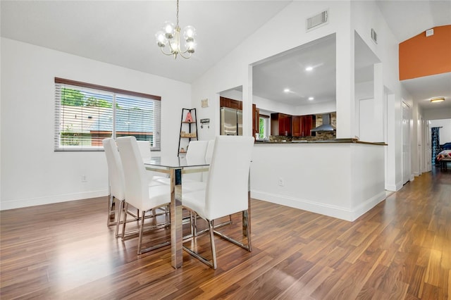 dining space featuring vaulted ceiling, an inviting chandelier, and dark hardwood / wood-style floors