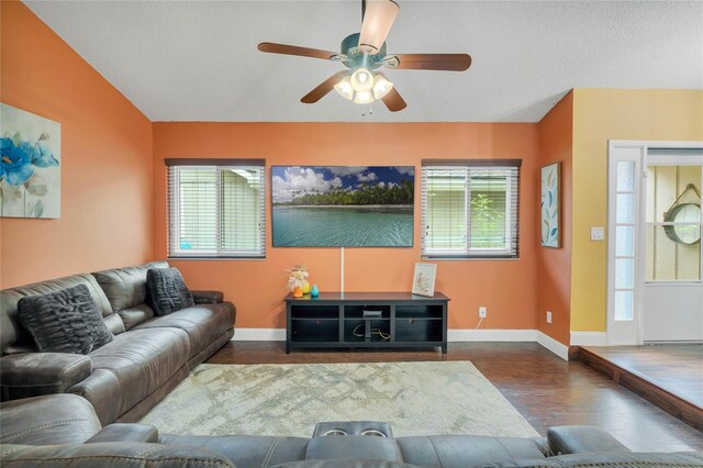 living room featuring dark hardwood / wood-style floors, a healthy amount of sunlight, a textured ceiling, and ceiling fan