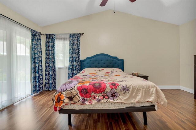 bedroom with multiple windows, lofted ceiling, and hardwood / wood-style floors