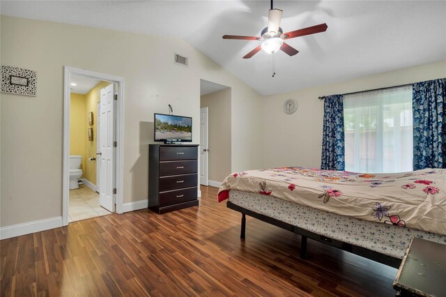 bedroom featuring hardwood / wood-style flooring, lofted ceiling, ensuite bath, and ceiling fan