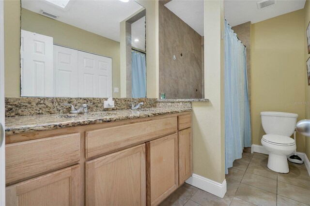 bathroom with vanity, tile patterned flooring, and toilet