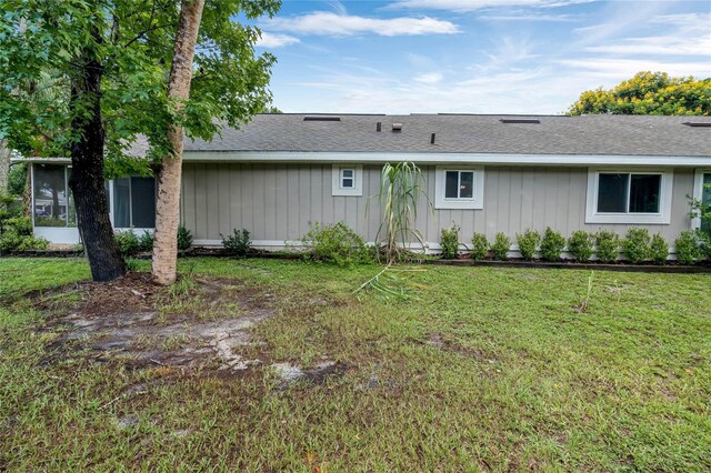 rear view of property featuring a lawn