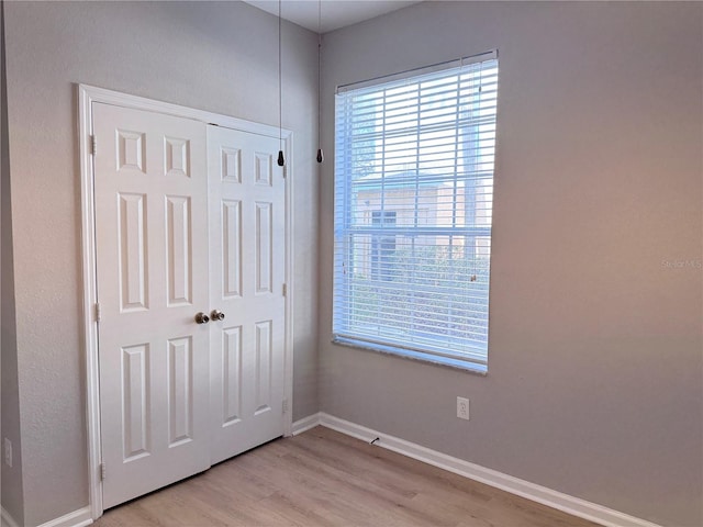 unfurnished bedroom with a closet and light wood-type flooring