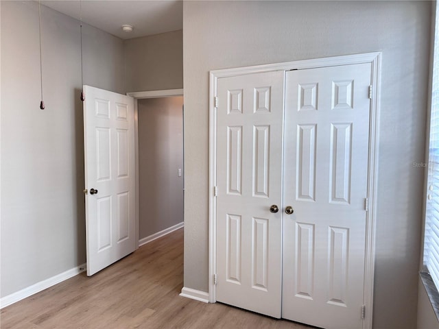 unfurnished bedroom with a closet and light wood-type flooring