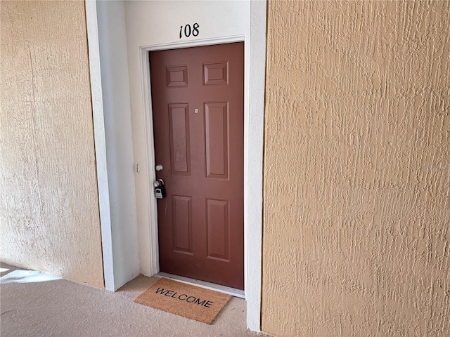 property entrance with stucco siding