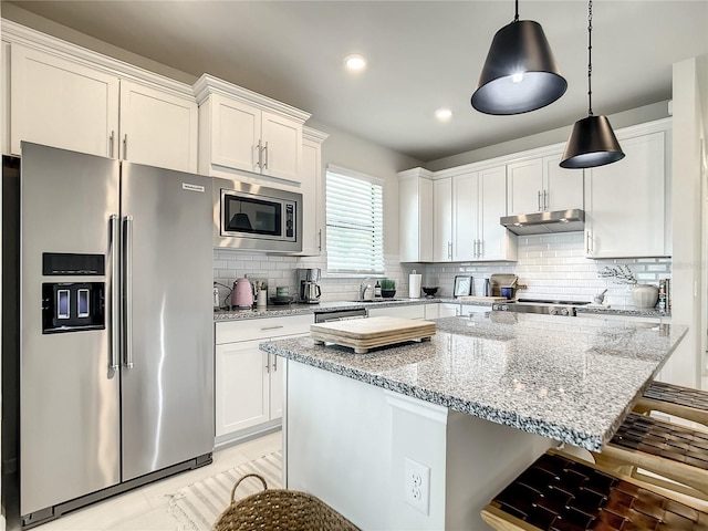 kitchen featuring stainless steel appliances, light stone counters, under cabinet range hood, and white cabinets