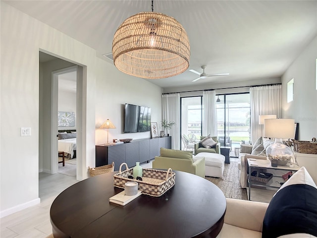 dining space featuring light wood-style floors, ceiling fan, and baseboards