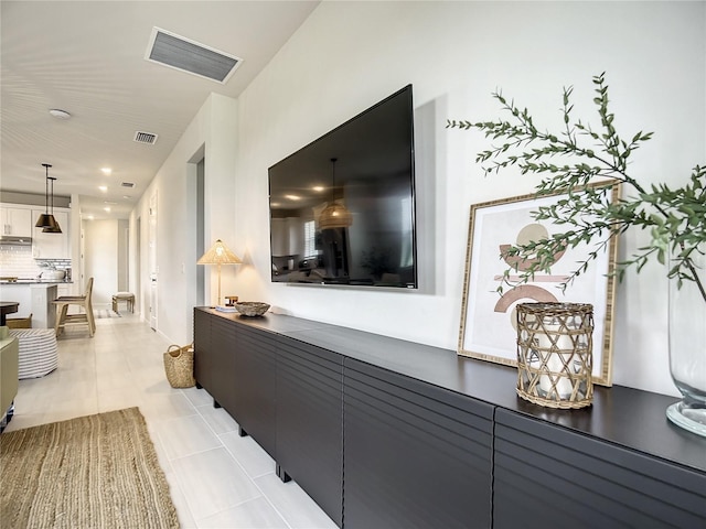 hallway featuring visible vents and light tile patterned flooring