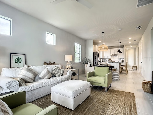 living room with light tile patterned floors, baseboards, and visible vents