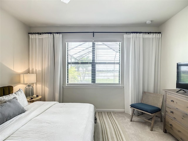 bedroom featuring baseboards and light colored carpet