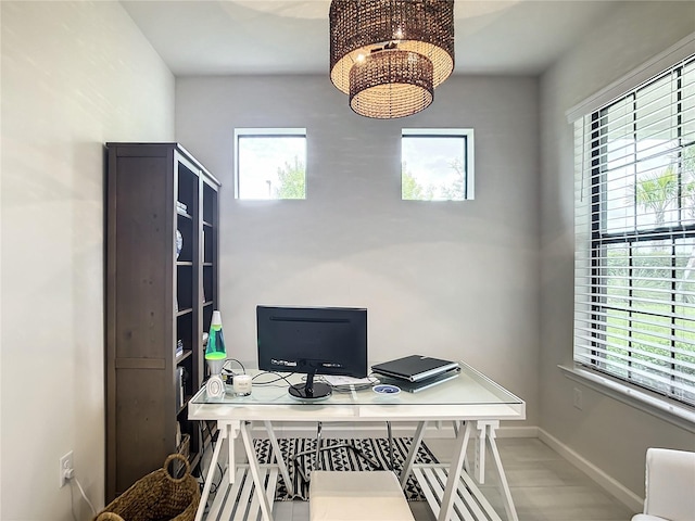 office space featuring an inviting chandelier and baseboards