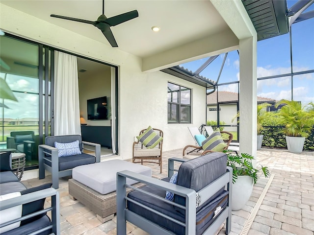 view of patio with ceiling fan, glass enclosure, and an outdoor living space