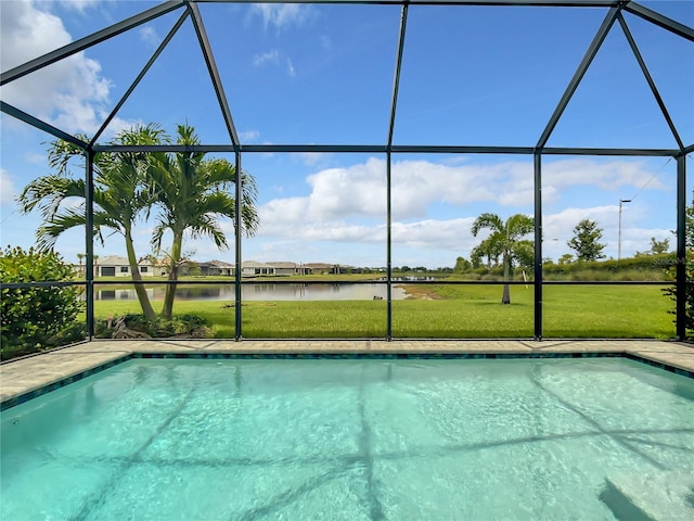 pool with a yard, glass enclosure, and a water view