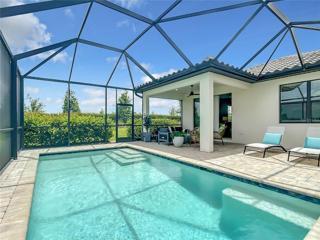 outdoor pool with a patio, a lanai, and a ceiling fan