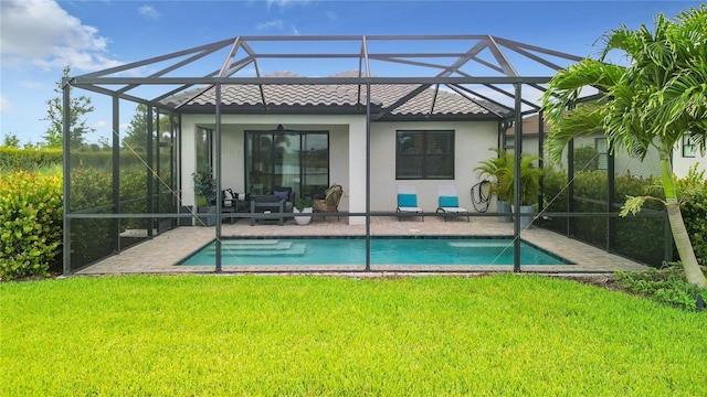 back of house with a patio, a yard, and a lanai