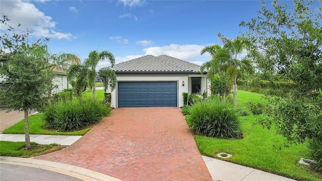 view of front of property with a garage, a tile roof, decorative driveway, stucco siding, and a front yard